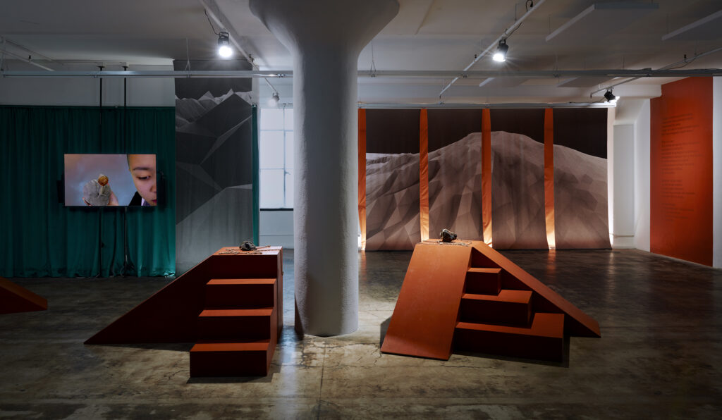 Various sculptures and a video are shown in a photograph of the exhibition entitled "Cassandra with a flood in her mouth" at JOAN Los Angeles (2023)